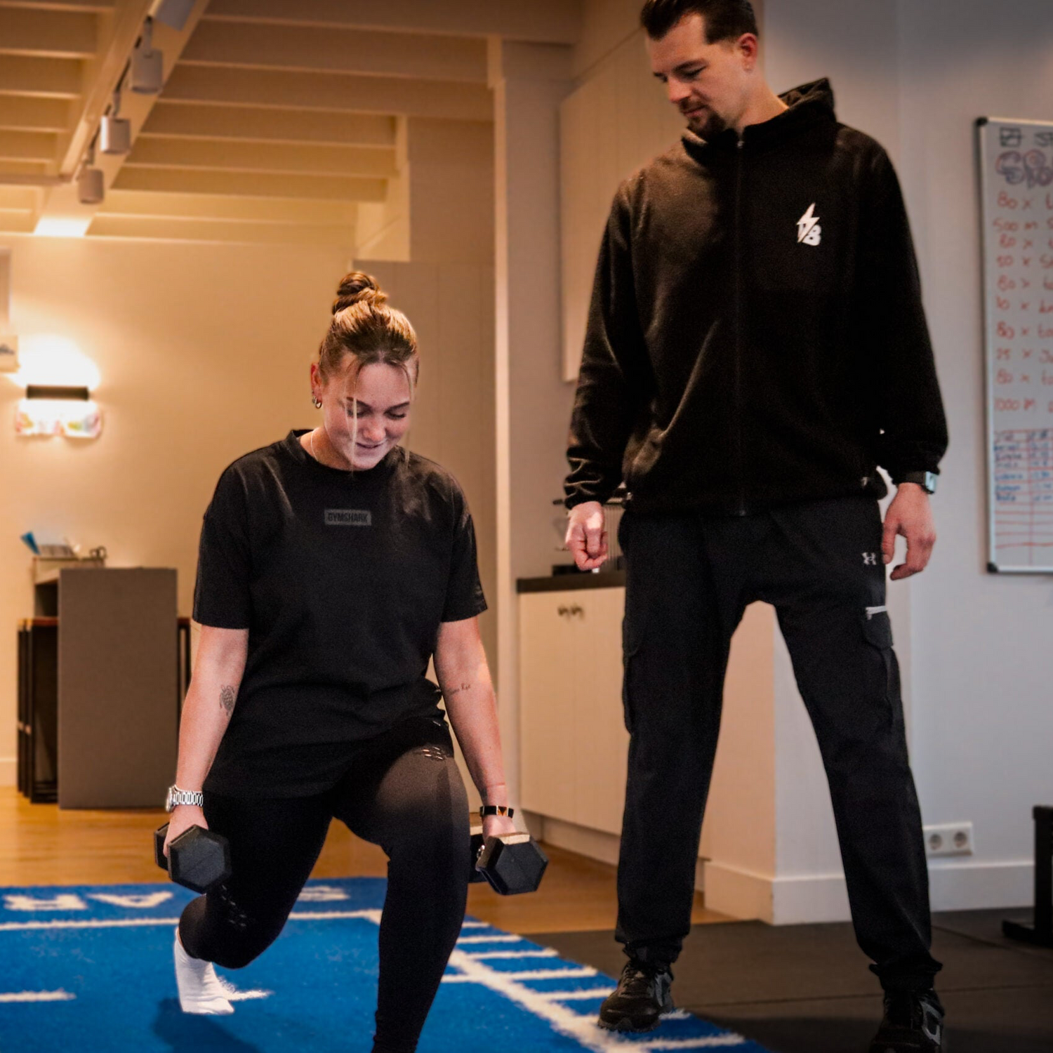 Boas geeft les aan een vrouw die haar benen, core en glutes traint onder persoonlijke begeleiding. Personal training met een advies op maat